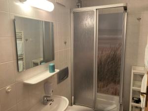 a bathroom with a shower and a sink and a toilet at Hotel-Pension Seeadler in Prerow +50 photos