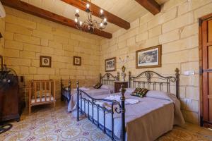a bedroom with two beds in a room at Ta' Kullarina Farmhouse in Żebbuġ +86 photos