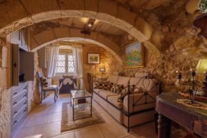 a living room with a couch and a stone wall at Ta' Kullarina Farmhouse in Żebbuġ