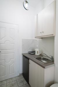 a kitchen with a sink and a white door at Studio Mary in Perissa