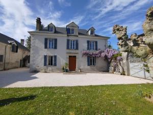 a large white house with a gate in front of it at B&B chez Nicole in Montaut