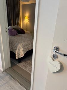 a door to a bedroom with a bed and a mirror at Karhulan Kammari, oma sisäänkäynti ja WC, Valkeakoski keskusta in Valkeakoski
