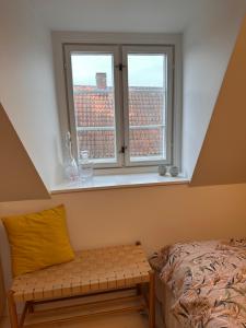 a bedroom with a window with a bench in front of it at Old Town Loft Middelfart in Middelfart