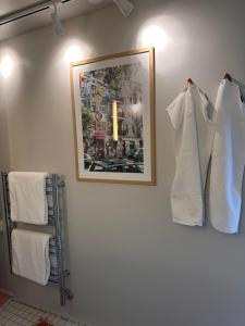 a bathroom with white towels and a picture on the wall at Old Town Loft Middelfart in Middelfart