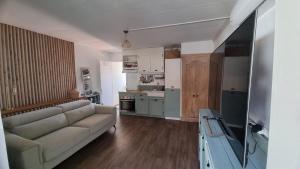 a living room with a couch and a kitchen at Studio Maison à Saint-Denis in Saint-Denis