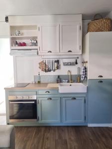 a kitchen with blue and white cabinets and a sink at Studio Maison à Saint-Denis in Saint-Denis +6 photos