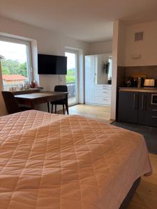 a bedroom with a large bed and a kitchen at Ferienwohnung Alpensteinbock in Nesselwang