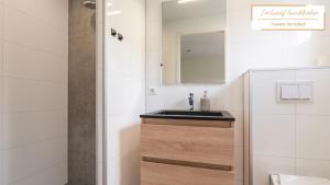 a bathroom with a sink and a mirror at Tiny House with decking | 2 persons in Gasselte +47 photos