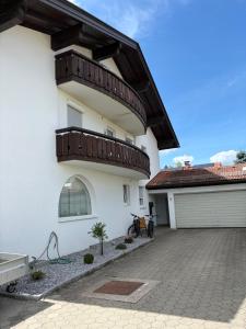 a white house with a balcony on it at Ferienwohnung Alpensteinbock in Nesselwang