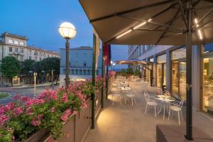 a restaurant with tables and chairs and flowers on a street at Sangallo Palace in Perugia