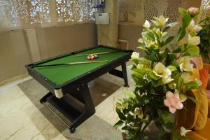 a green pool table with a snooker ball on it at Aurelia INN - JP Nagar in Bangalore