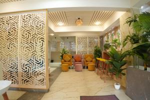 a lobby with a waiting room with orange chairs at Aurelia INN - JP Nagar in Bangalore