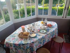 a table with breakfast food on it in a room with windows at les chambres du Kergolo in Plouézec