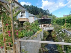 a house with a bridge over a stream with a garden at les chambres du Kergolo in Plouézec
