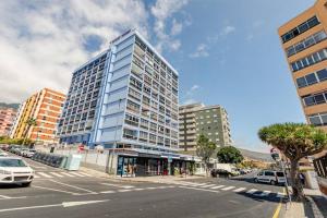 a large tall building on a city street with cars at The beach nest in Candelaria