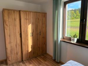 a bedroom with a large wooden cabinet and a window at Biała Ostoja 517-539-965 in Berezka