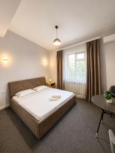a bedroom with a large bed and a window at Grand Sky Hotel in Almaty