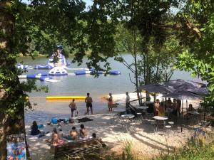 a group of people on a beach near a body of water at camping du Coucou in Nailhac +10 photos