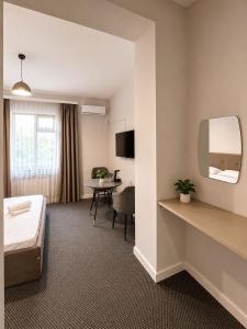 a hotel room with a bed and a table at Grand Sky Hotel in Almaty