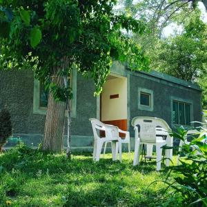 two chairs and a table in front of a house at Mullberry Lodge Gulmit in Chamangul