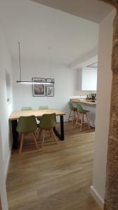 a dining room with a table and green chairs at Casa rural Villa Quintans in Soutullo