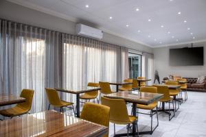 a restaurant with tables and chairs and a flat screen tv at Guest at 58 in Lydenburg