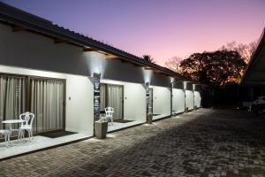 a building with a row of windows with chairs on it at Guest at 58 in Lydenburg