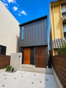 a house with a brown door and a fence at Villa Monica Premium in Nagoya