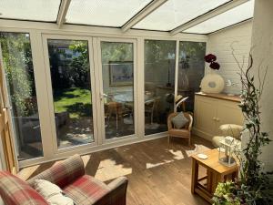 a conservatory with sliding glass doors and a table at The Hideaway in Llandudno
