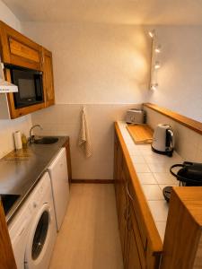 a kitchen with a sink and a washing machine at Cozy studio balcon et parking in Font-Romeu