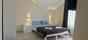 a bedroom with a bed and a night stand with two lights at Hotel Osher in Bukovel
