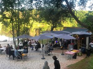 a group of people sitting at tables with umbrellas at camping du Coucou in Nailhac