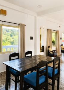 a dining room with a wooden table and chairs at Bhumika by evaddo stays in Mandrem