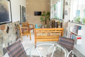 a living room with two chairs and a table at Pousada Mar E Mata in Guarapari
