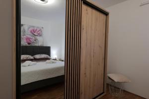 a bedroom with a large mirror and a bed at Apartment Jugo in Preko