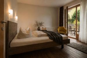 a bedroom with a bed with a view of a patio at Appartments Gerlos Am Bach - Riverside in Gerlos