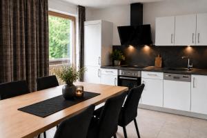 a kitchen with a wooden table with chairs and a dining room at Appartments Gerlos Am Bach - Riverside in Gerlos