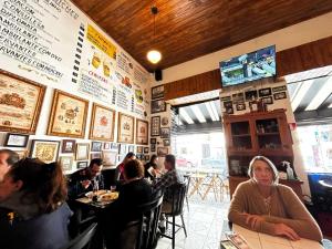 a group of people sitting at tables in a restaurant at Confortavel Apartamento na Rua das Flores in Curitiba