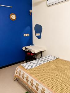 a room with a bed and a table and a clock at Veena Vihar Homestay in Jodhpur +13 photos