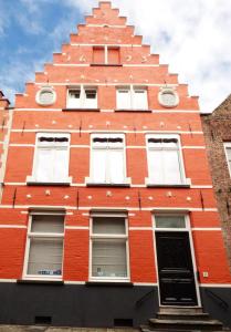 a red building with white windows at B&B Lady Jane in Bruges
