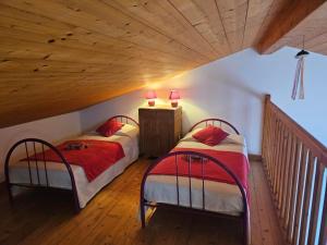 two beds in a room with a wooden ceiling at Maison 3 étoiles à 50m mer plages îles nature piscine chauffée jacuzzi privé WIFI in Le Port-des-Barques +19 photos