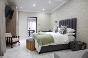 a bedroom with a large bed and a chair at Guest at 58 in Lydenburg
