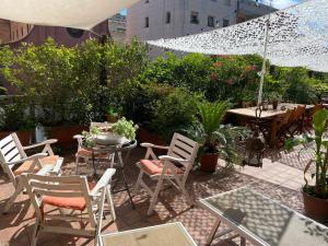 a patio with chairs and tables and an umbrella at Camera con bagno privato e terrazzo a 10 minuti dalla Stazione Centrale - Oasis Bologna Centro in Bologna