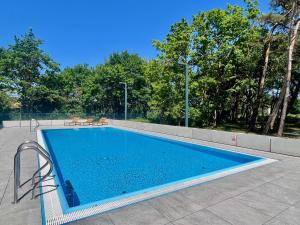a swimming pool with two chairs next to it at Nautic Park Apartamenty in Darlowko