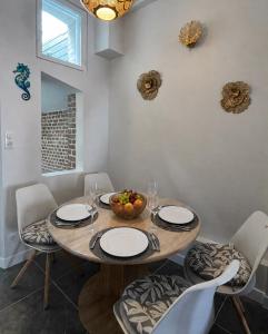 a table with chairs and a bowl of fruit on it at La Villa Turquoise in Le Tréport