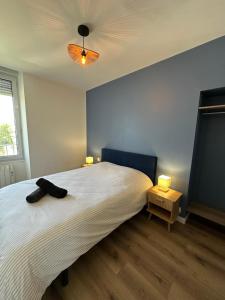 a bedroom with a large white bed with two lamps at Le Nid de la Mayenne in Mayenne