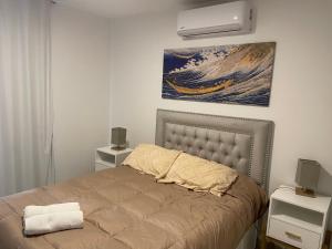 a bedroom with a bed and a painting on the wall at Torres al mar 10 in Monte Hermoso