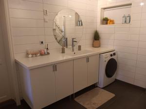 a bathroom with a sink and a washing machine at Studio Leilighet in Moss