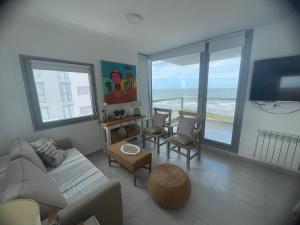 a living room with a couch and a table with chairs at Torres al mar 10 in Monte Hermoso