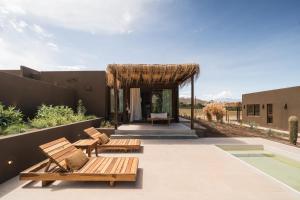 patio z dwiema drewnianymi ławkami i pawilonem w obiekcie Macal Cachi Luxury Lodge w mieście Cachí
